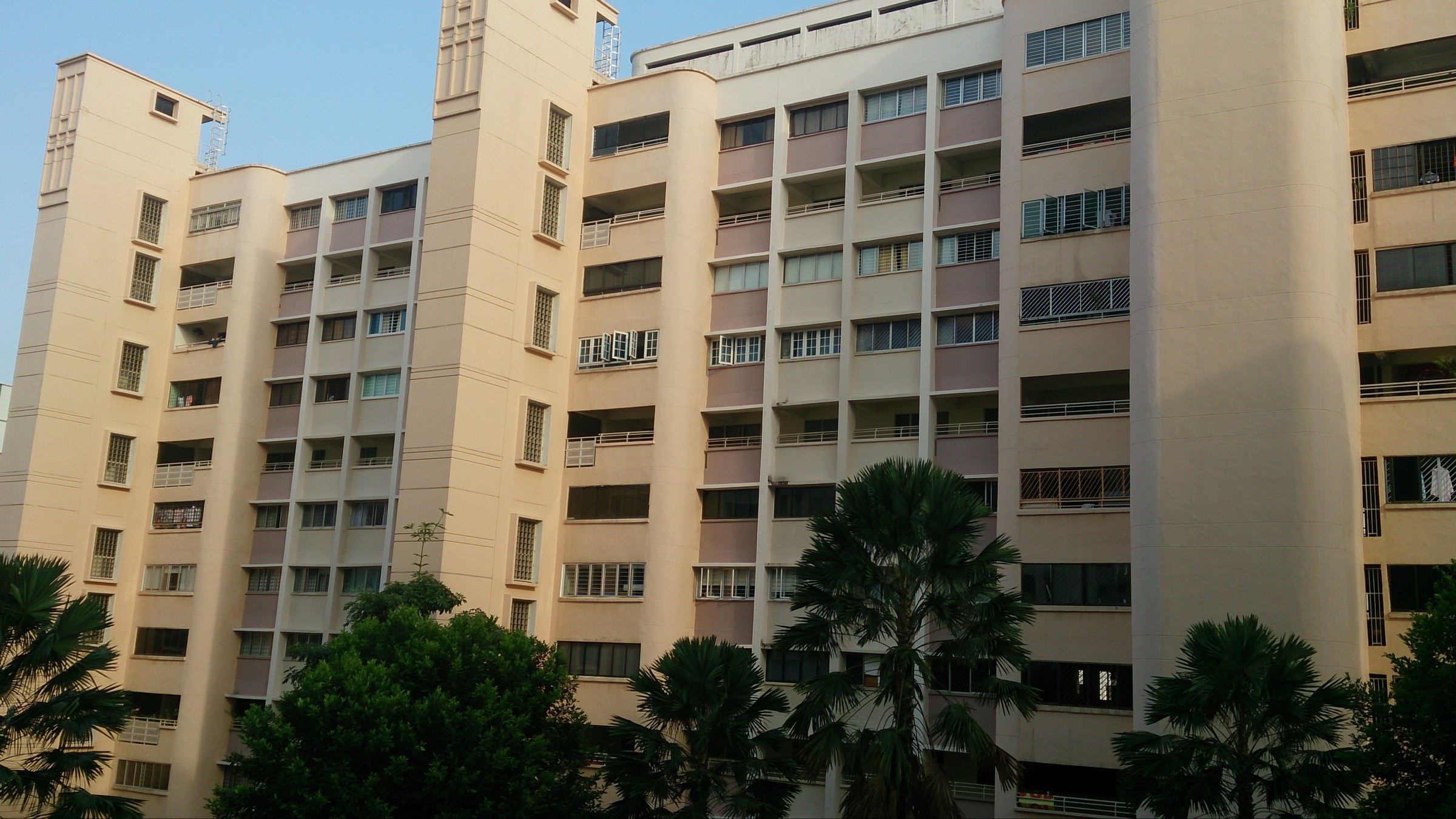 HDB flats along Lorong Ah Soo with mature trees in the foreground.