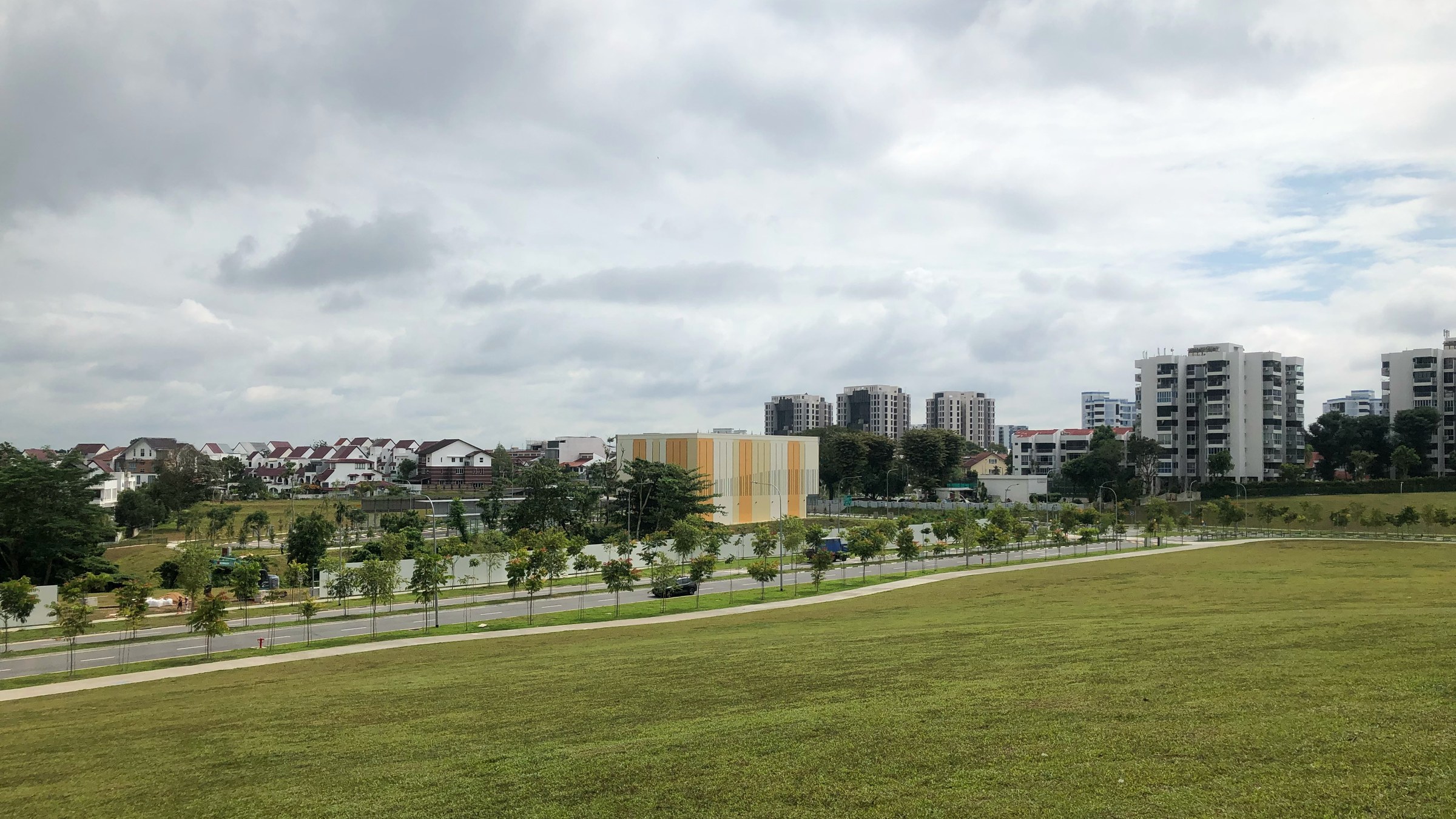 A wide view over the Lentor estate with landed houses in front and new condominium towers rising behind.