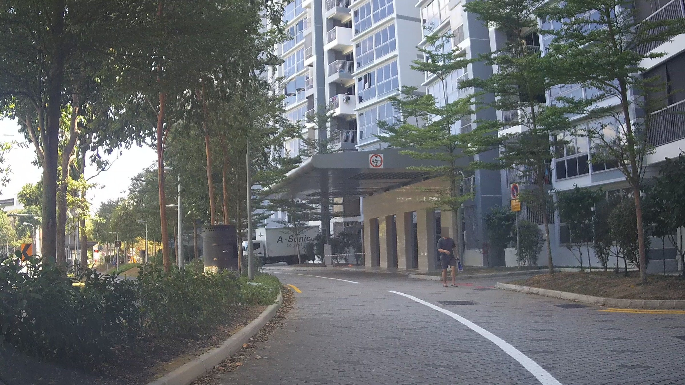 A tower of Pasir Ris One at Pasir Ris Drive 1, seen from the estate's internal driveway, with its sheltered drop-off porch in front.