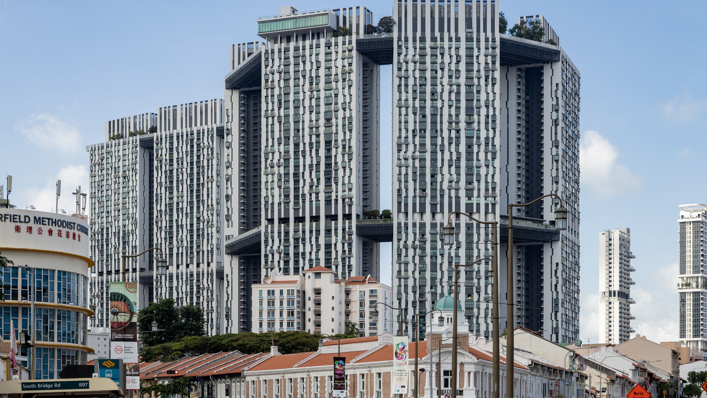The Pinnacle@Duxton HDB towers rising behind conserved shophouses, with a private condominium tower alongside.