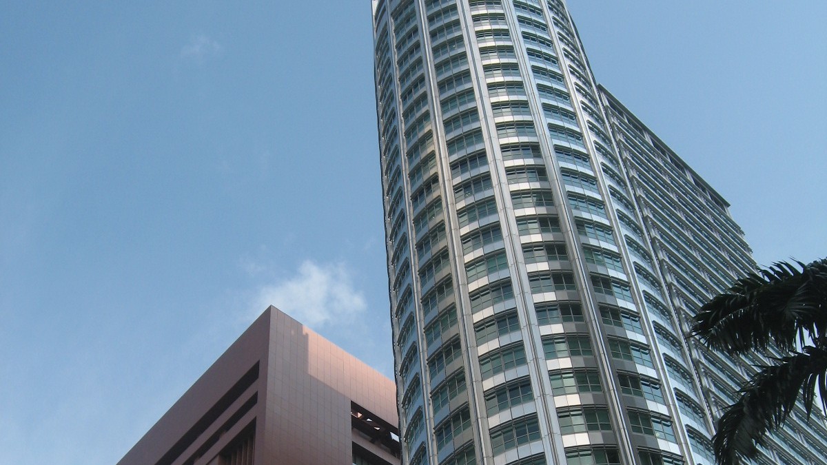 Looking up at Springleaf Tower's curved glass and steel facade at 3 Anson Road in Tanjong Pagar, with the corner of a neighbouring building on the left.
