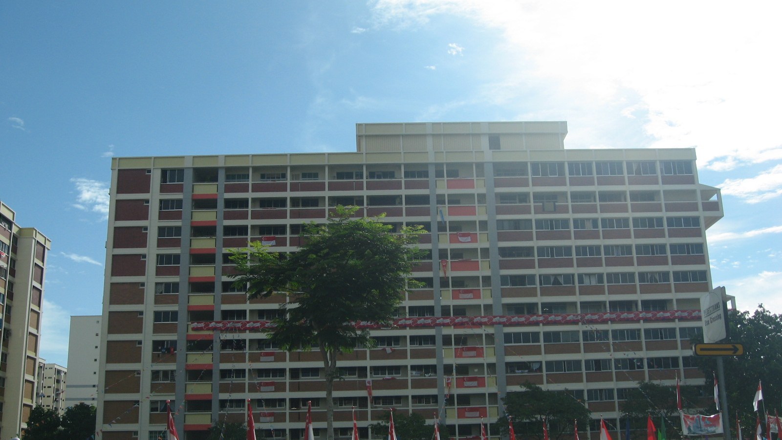 A high-rise HDB block in Tampines decorated with Singapore flags.